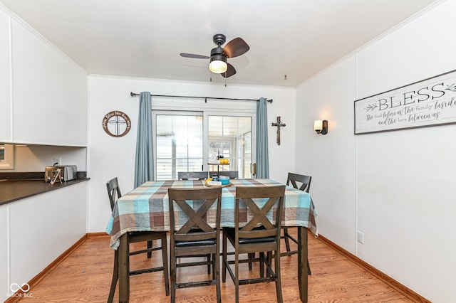 dining room featuring crown molding, ceiling fan, and light wood-type flooring