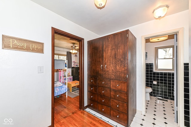 bathroom featuring tile walls and toilet