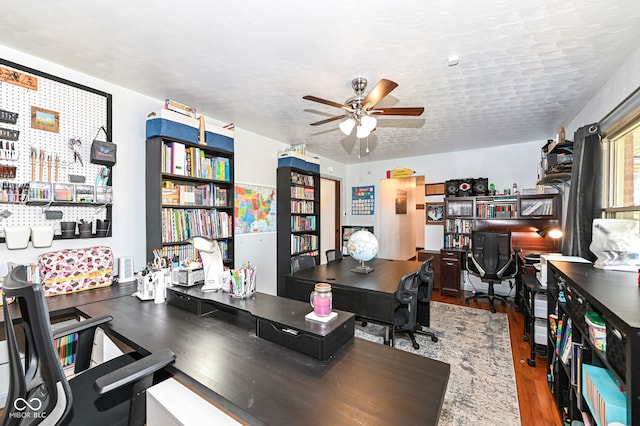 office space featuring hardwood / wood-style flooring, ceiling fan, and a textured ceiling