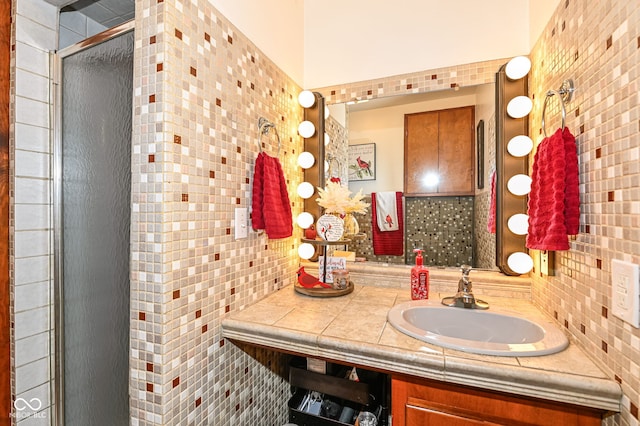 bathroom with tasteful backsplash, vanity, and a shower with door