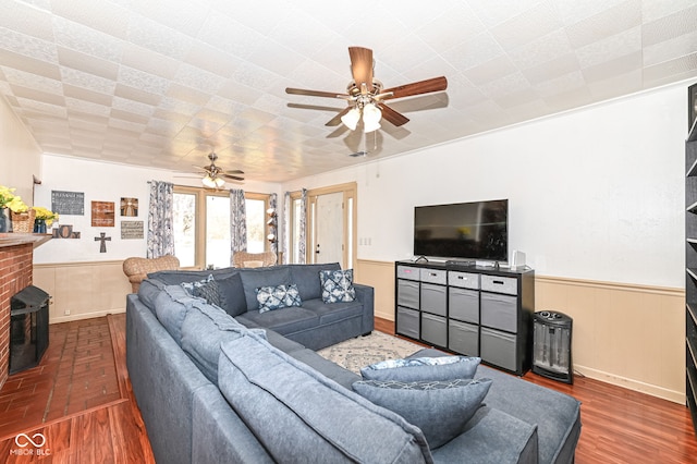 living room with ceiling fan, dark hardwood / wood-style flooring, and a brick fireplace