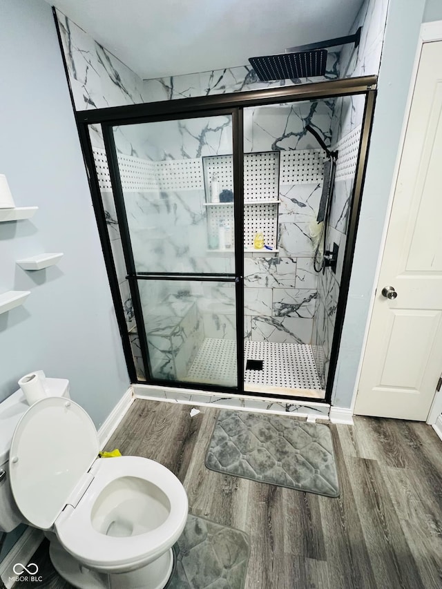 bathroom with hardwood / wood-style flooring, toilet, and walk in shower