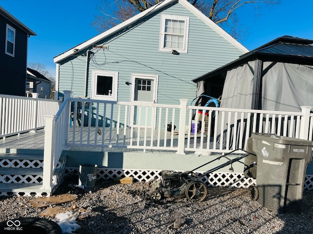 rear view of house featuring a wooden deck and a gazebo