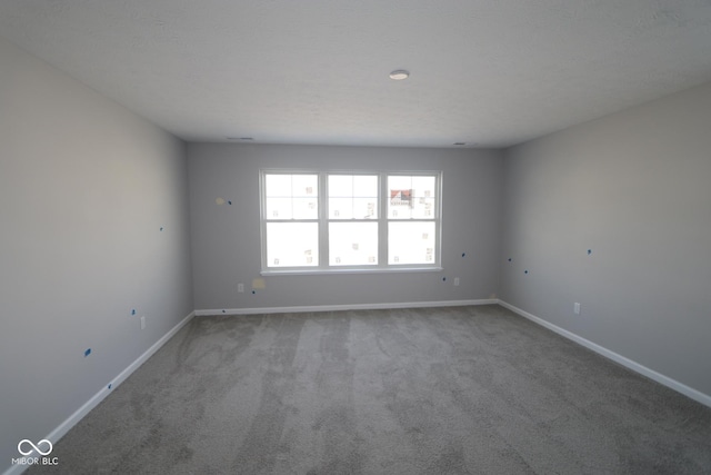 carpeted spare room with baseboards