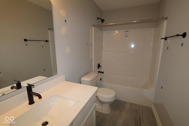 full bathroom with toilet, washtub / shower combination, wood finished floors, and vanity