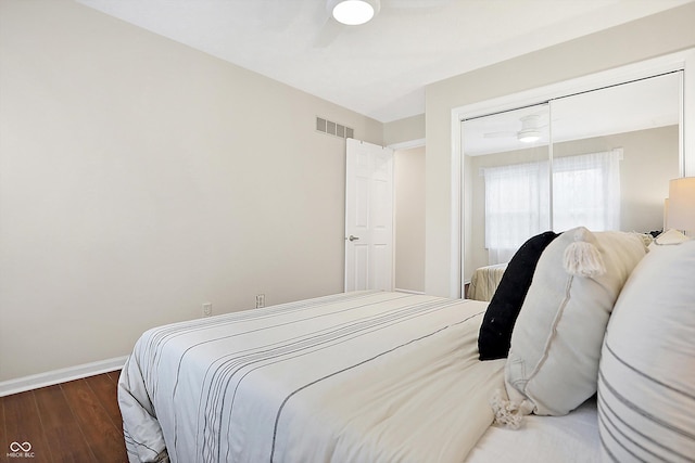 bedroom with a closet, dark hardwood / wood-style floors, and ceiling fan