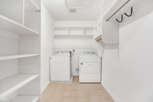 laundry area with light tile patterned floors and washer and clothes dryer