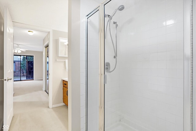 bathroom featuring a shower with door, vanity, and ceiling fan