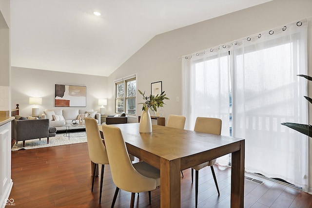 dining area with hardwood / wood-style flooring and vaulted ceiling