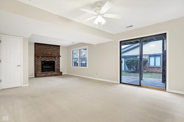 unfurnished living room featuring ceiling fan, a brick fireplace, and carpet