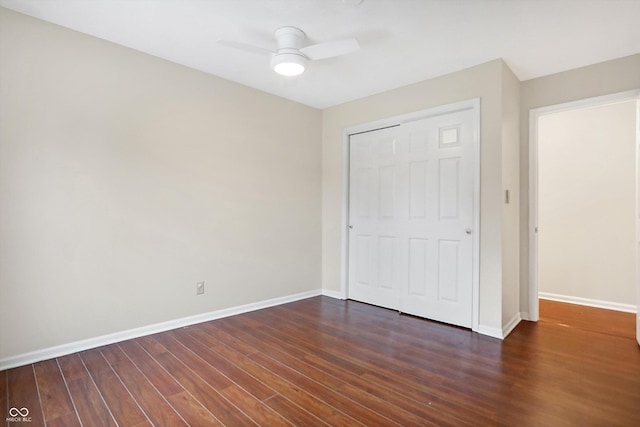 unfurnished bedroom with a closet, dark hardwood / wood-style floors, and ceiling fan