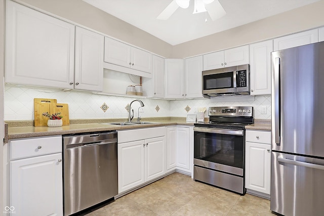 kitchen featuring light tile patterned flooring, tasteful backsplash, white cabinetry, sink, and stainless steel appliances