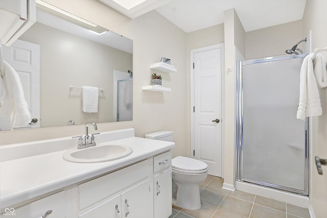 bathroom featuring tile patterned floors, toilet, a shower with shower door, and vanity