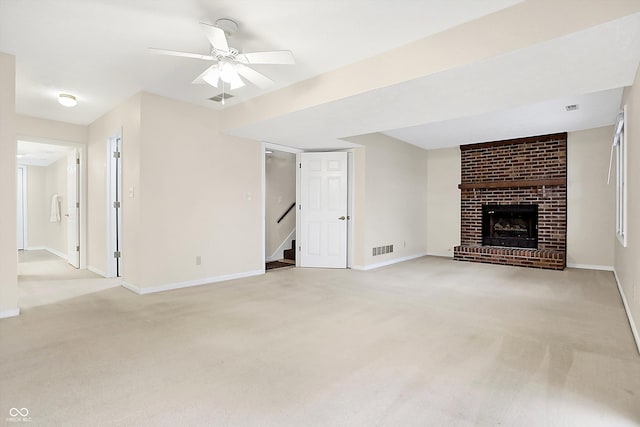 unfurnished living room with ceiling fan, a fireplace, and light carpet