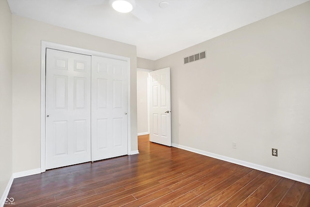 unfurnished bedroom featuring dark wood-type flooring and a closet