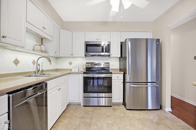 kitchen featuring sink, ceiling fan, appliances with stainless steel finishes, white cabinetry, and decorative backsplash