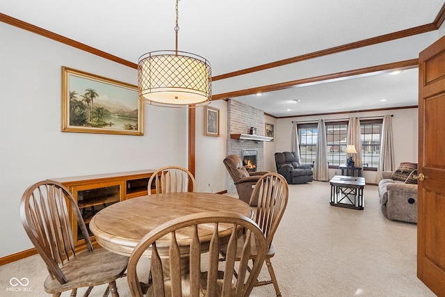 dining space featuring light carpet, ornamental molding, a brick fireplace, and baseboards