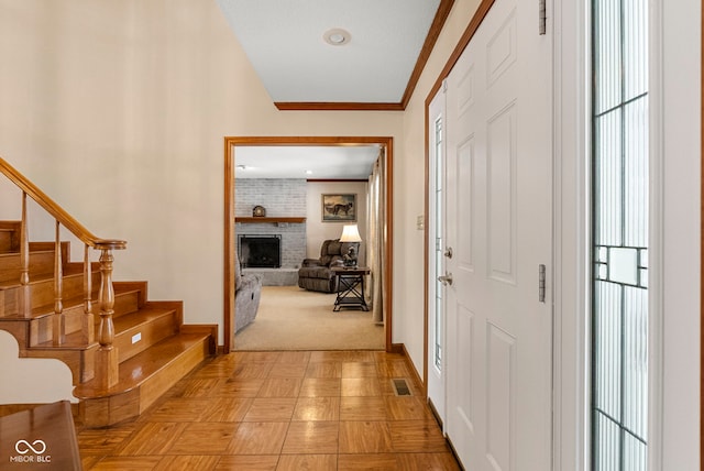 entrance foyer with a healthy amount of sunlight, visible vents, a fireplace, and stairs