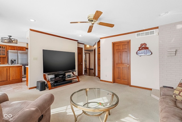 living room featuring light carpet, a ceiling fan, visible vents, baseboards, and ornamental molding