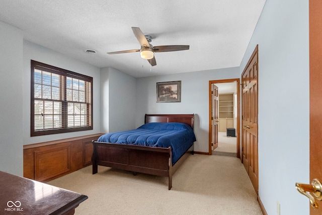 bedroom featuring light carpet, baseboards, visible vents, and a textured ceiling