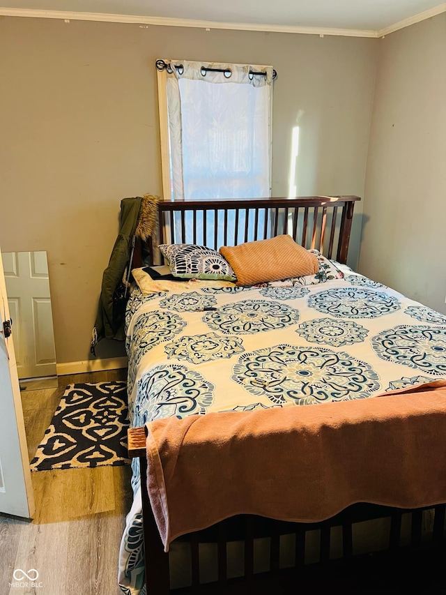 bedroom featuring crown molding and hardwood / wood-style floors