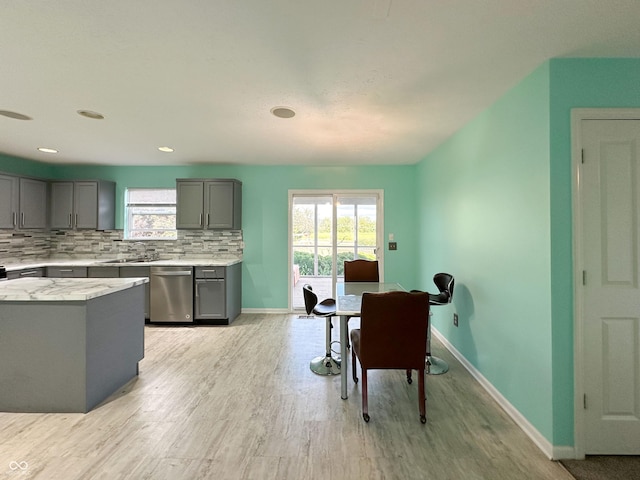 dining room with sink, light hardwood / wood-style flooring, and a healthy amount of sunlight