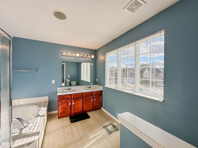 bathroom with vanity, tile patterned flooring, a textured ceiling, and a bathing tub