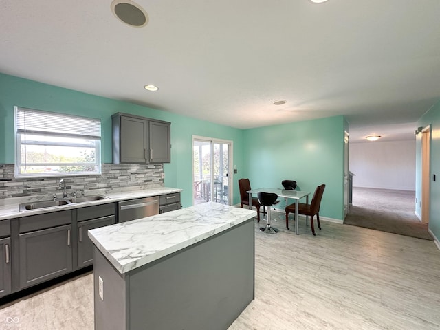 kitchen with sink, dishwasher, tasteful backsplash, a wealth of natural light, and a kitchen island