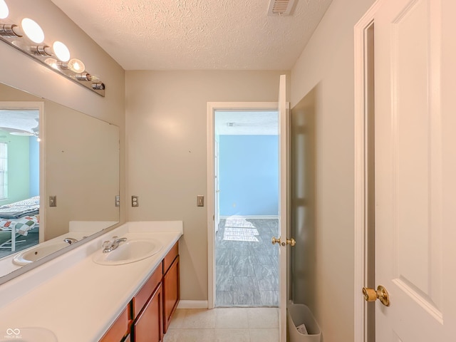 bathroom featuring tile patterned flooring, vanity, and a textured ceiling