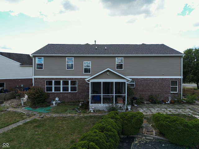 rear view of house with a yard and a sunroom