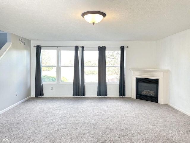 unfurnished living room featuring carpet floors and a textured ceiling