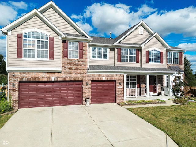 view of front of property featuring a garage, a porch, and a front lawn