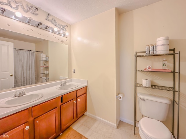 bathroom with vanity, toilet, tile patterned flooring, and a textured ceiling