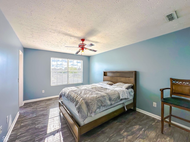 bedroom with dark wood-type flooring, ceiling fan, and a textured ceiling