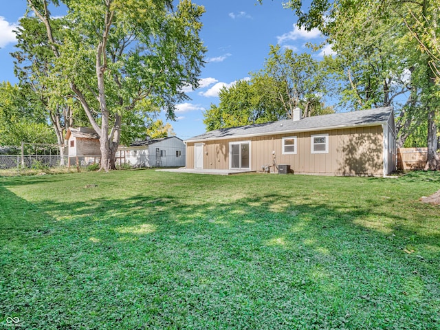 rear view of house featuring a patio, a yard, and central AC unit