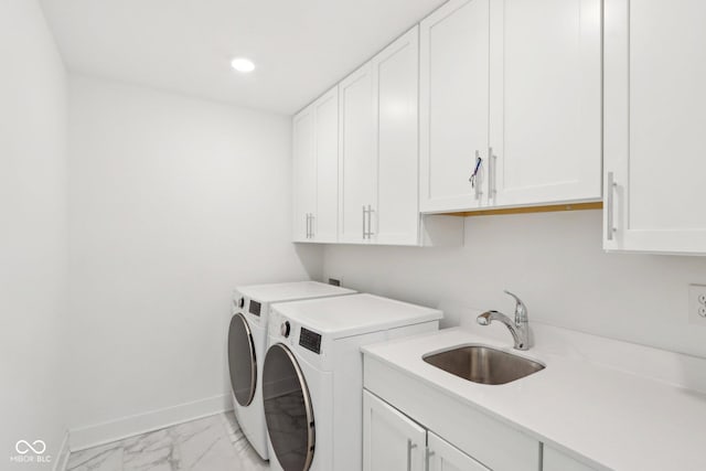 washroom with cabinets, sink, and washer and dryer