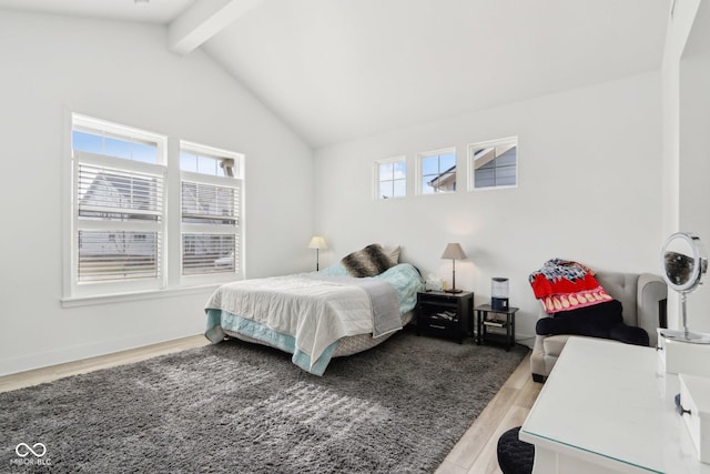 bedroom featuring light hardwood / wood-style flooring and vaulted ceiling with beams