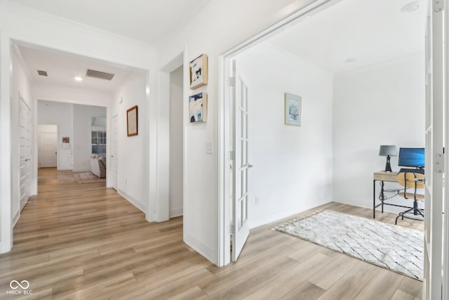 corridor with crown molding and light hardwood / wood-style flooring