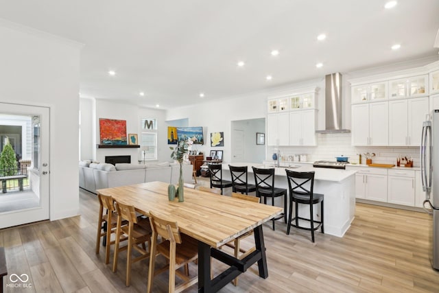 dining area featuring crown molding and light hardwood / wood-style floors