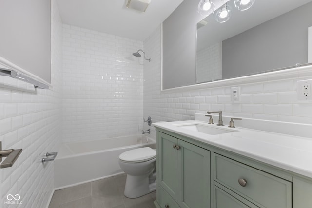 full bathroom featuring tile walls, tile patterned flooring, vanity, toilet, and tiled shower / bath