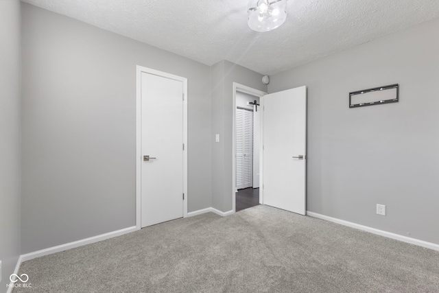 unfurnished bedroom featuring a textured ceiling and carpet