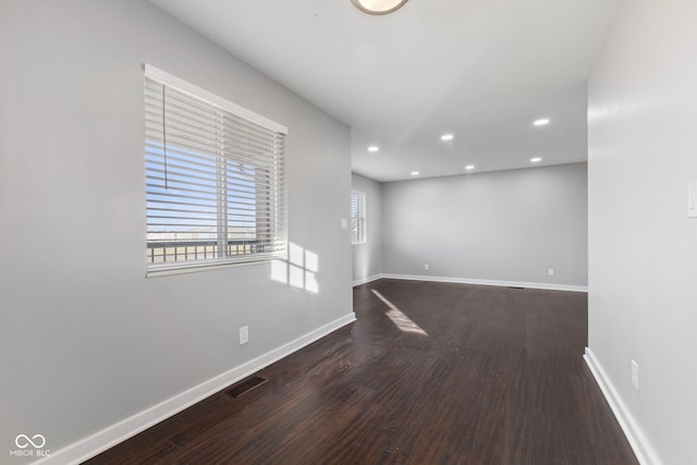 empty room with dark hardwood / wood-style flooring