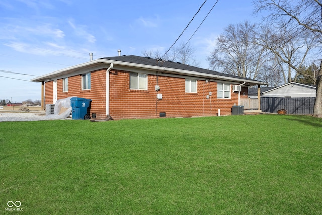 rear view of property featuring a yard and central AC unit