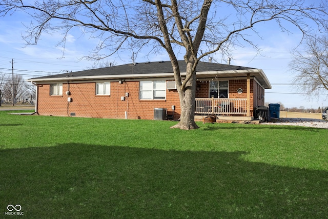 rear view of house featuring covered porch, central AC, and a lawn