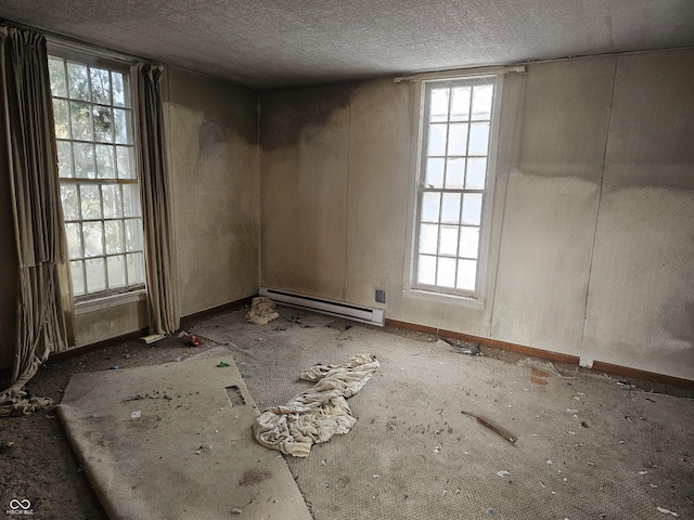 unfurnished room featuring a baseboard radiator and a textured ceiling