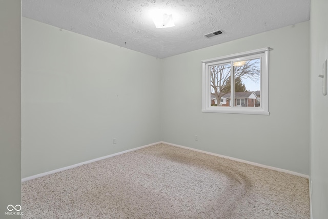 spare room featuring carpet floors and a textured ceiling