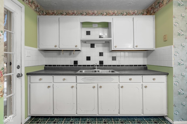 kitchen with white cabinetry, sink, and a textured ceiling