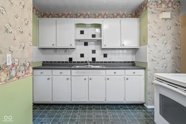 kitchen with sink, a textured ceiling, white cabinets, white range with electric stovetop, and backsplash