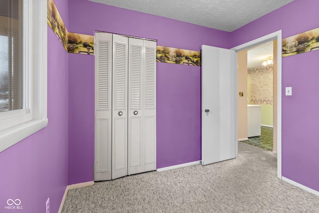 unfurnished bedroom with a closet, carpet, and a textured ceiling