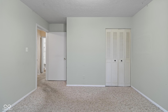 unfurnished bedroom with light carpet, a closet, and a textured ceiling